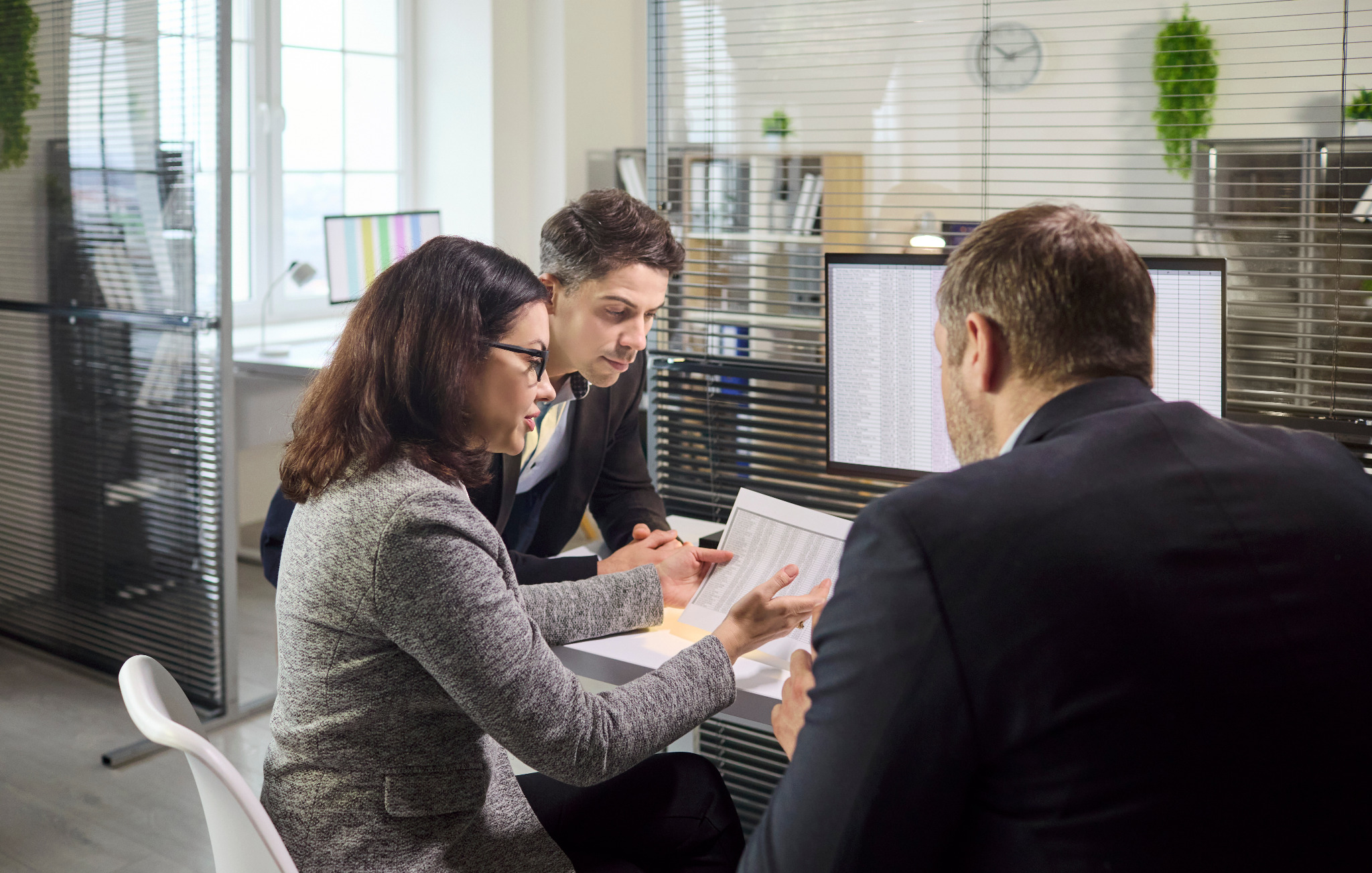 Three professionals reviewing financial information
